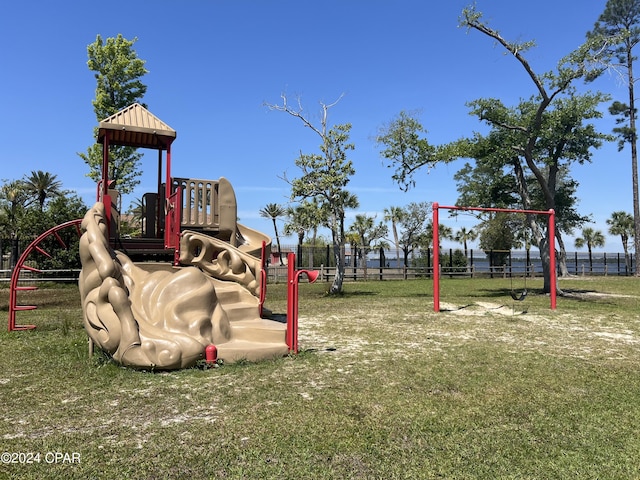 community play area with fence and a yard