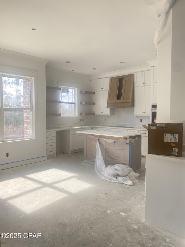 kitchen with open shelves, premium range hood, stainless steel oven, and white cabinetry