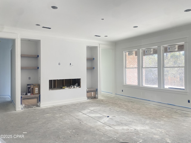 unfurnished living room with visible vents, a fireplace, and built in features