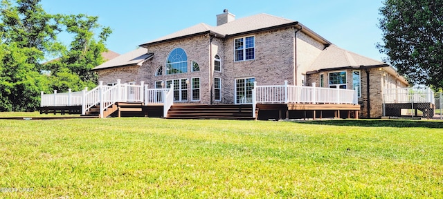 rear view of property featuring a yard and a deck