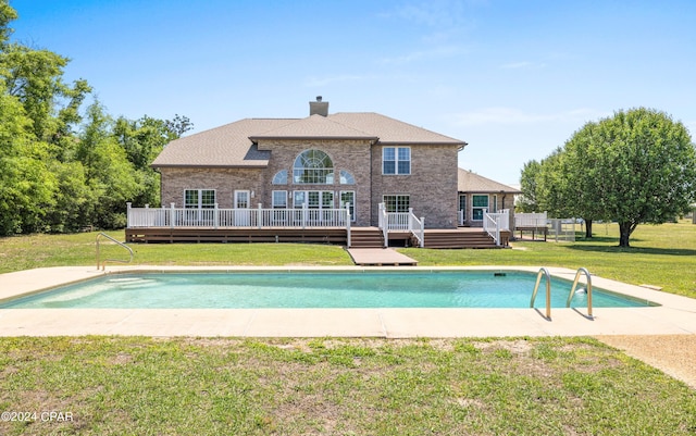 view of swimming pool with a wooden deck and a yard