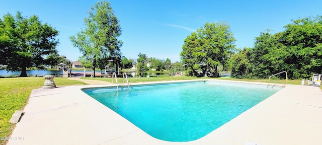 view of swimming pool with a lawn