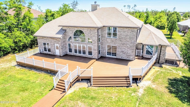 back of property featuring a deck and a yard