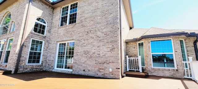 rear view of house featuring a wooden deck