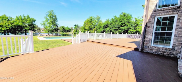 deck featuring a pool and a lawn