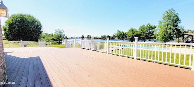 deck featuring a fenced in pool and a yard