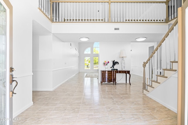 tiled foyer entrance featuring a towering ceiling