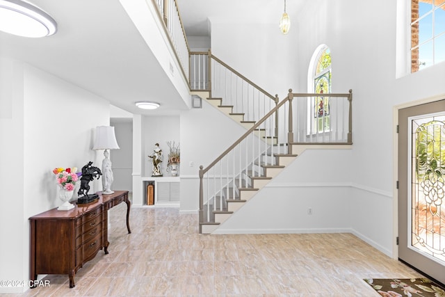 entryway featuring a high ceiling and light tile patterned flooring