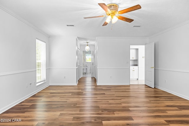 unfurnished bedroom with multiple windows, ceiling fan, connected bathroom, and hardwood / wood-style flooring