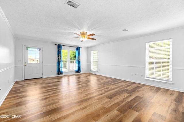 unfurnished living room featuring ceiling fan, a textured ceiling, crown molding, and wood-type flooring