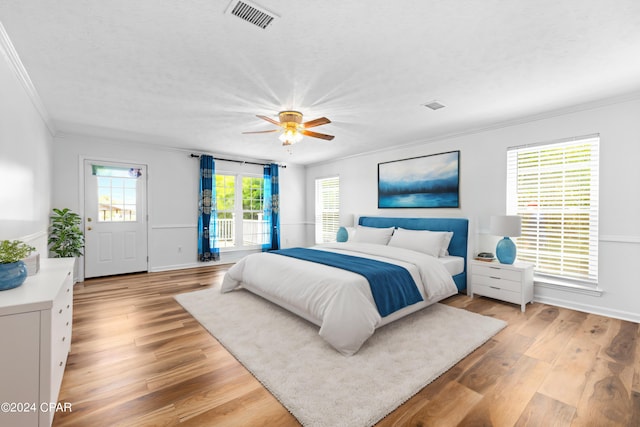 bedroom with ceiling fan, light hardwood / wood-style floors, access to exterior, and crown molding