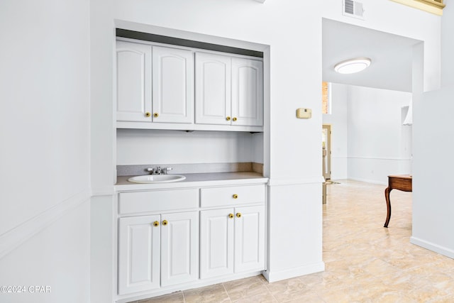 kitchen with sink, white cabinets, and light tile patterned floors