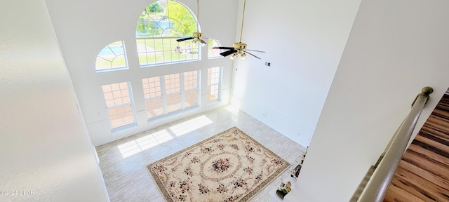 foyer entrance featuring ceiling fan and a towering ceiling