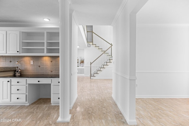 hallway with crown molding, ornate columns, and light tile patterned floors