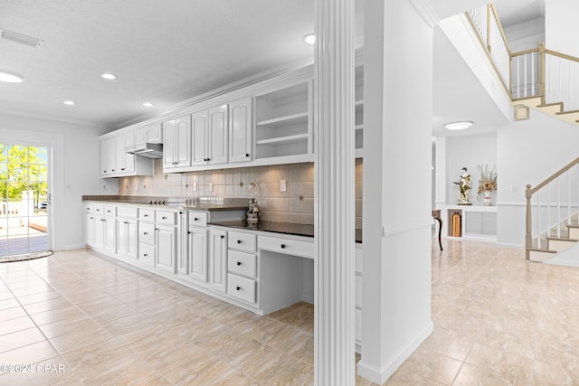 kitchen with tasteful backsplash, white cabinetry, and light tile patterned flooring