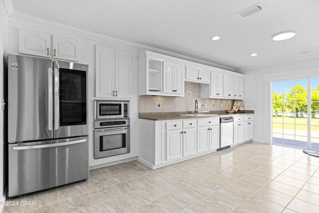 kitchen featuring sink, stainless steel appliances, tasteful backsplash, and white cabinets