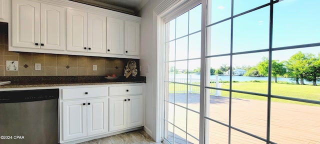 kitchen with a wealth of natural light, decorative backsplash, a water view, stainless steel dishwasher, and white cabinetry