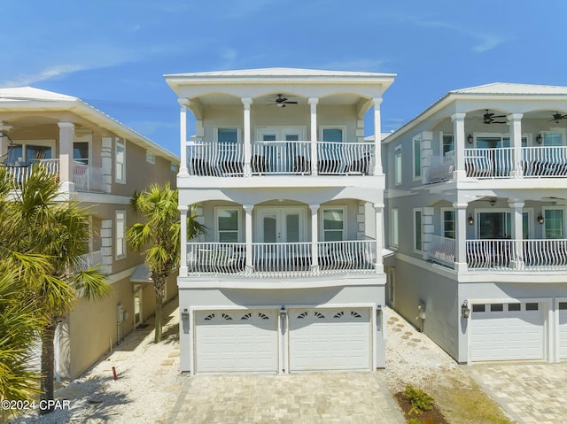 back of property with a balcony, a garage, and ceiling fan