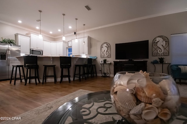 living room featuring crown molding and hardwood / wood-style flooring