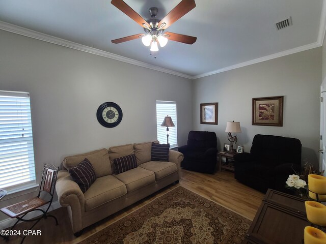 living room with a wealth of natural light, ceiling fan, crown molding, and hardwood / wood-style flooring