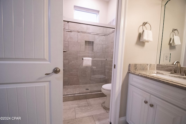 bathroom featuring tile flooring, a shower with door, vanity, and toilet