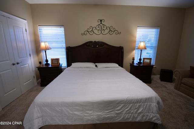 bedroom with dark colored carpet, a closet, and multiple windows