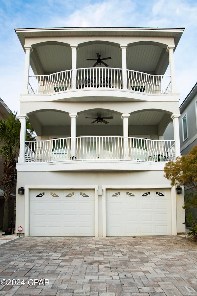 view of front of property with a balcony, a garage, and ceiling fan