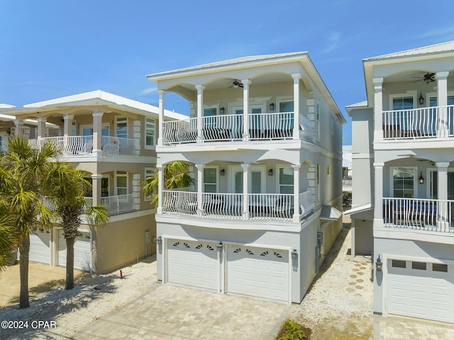 back of house featuring a garage, ceiling fan, and a balcony