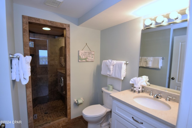 bathroom featuring tile patterned flooring, toilet, an enclosed shower, and vanity