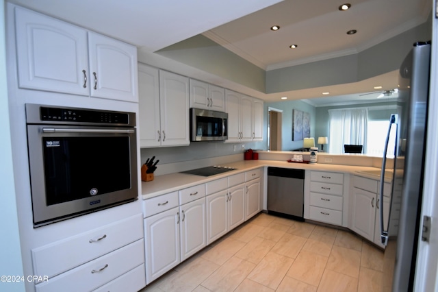 kitchen with stainless steel appliances, white cabinetry, and crown molding