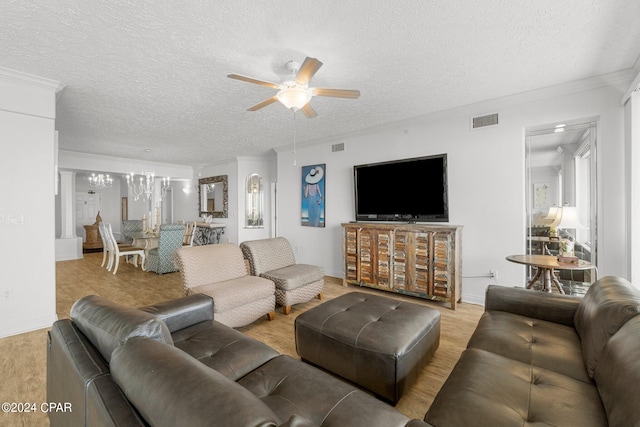 living room featuring ceiling fan with notable chandelier, ornamental molding, light hardwood / wood-style flooring, and a textured ceiling