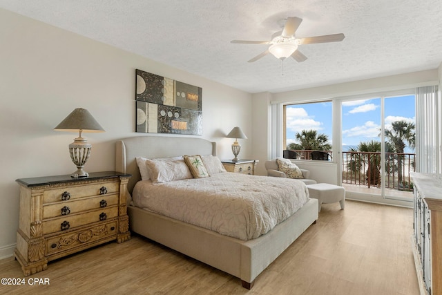 bedroom featuring light hardwood / wood-style floors, ceiling fan, access to outside, and a textured ceiling