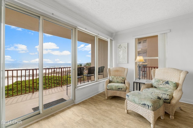 sunroom / solarium with a water view and a view of the beach