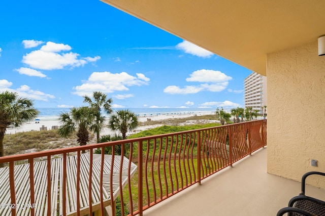 balcony featuring a beach view and a water view