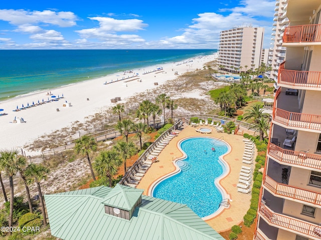 view of swimming pool featuring a water view and a beach view