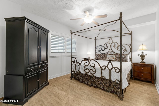 bedroom featuring a textured ceiling, ceiling fan, and light wood-type flooring