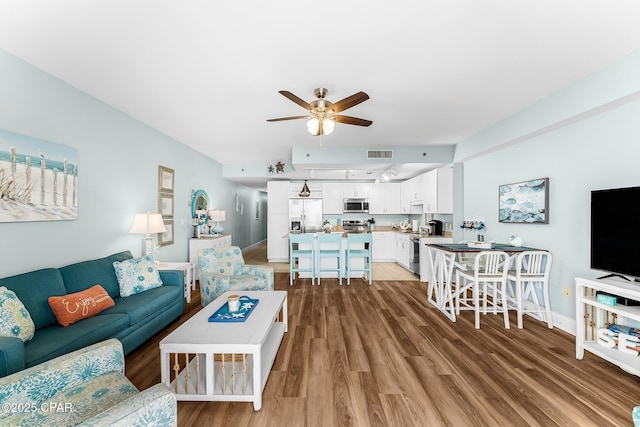 living room with hardwood / wood-style flooring and ceiling fan