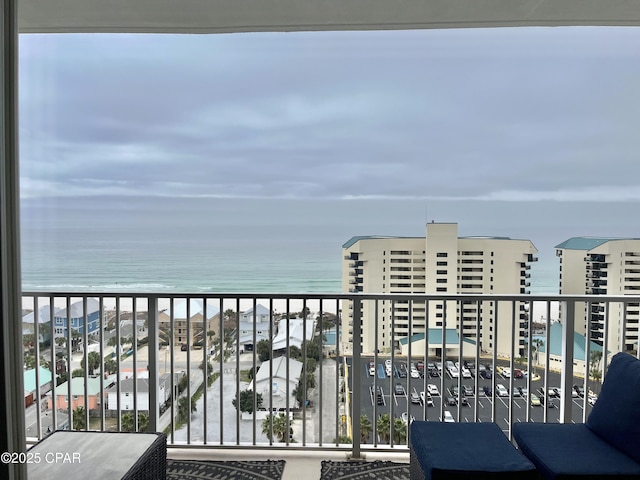 balcony featuring a view of the beach and a water view