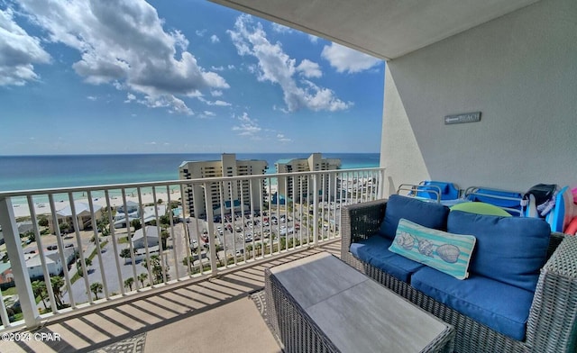 balcony with a water view, a view of the beach, and outdoor lounge area