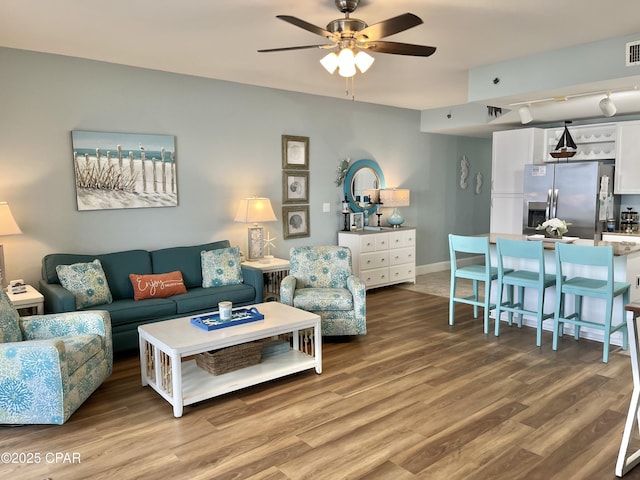 living room featuring hardwood / wood-style floors and ceiling fan