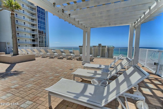 view of patio / terrace with a pergola and a water view