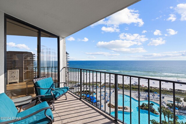 balcony featuring a water view and a community pool