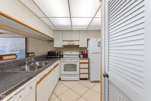 kitchen with a drop ceiling, white appliances, light tile flooring, white cabinets, and sink