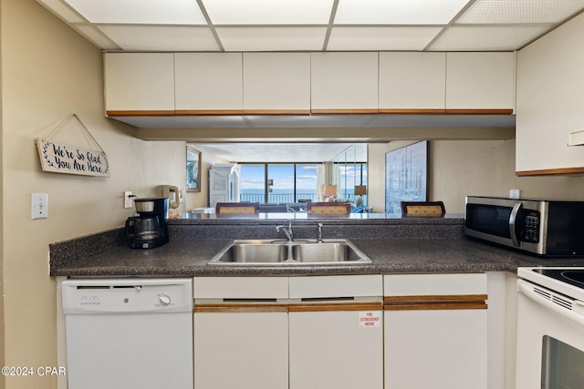 kitchen with white cabinetry, a drop ceiling, white appliances, and sink