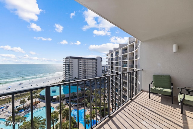 balcony featuring a beach view and a water view