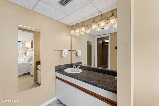 bathroom with a drop ceiling, oversized vanity, and tile floors