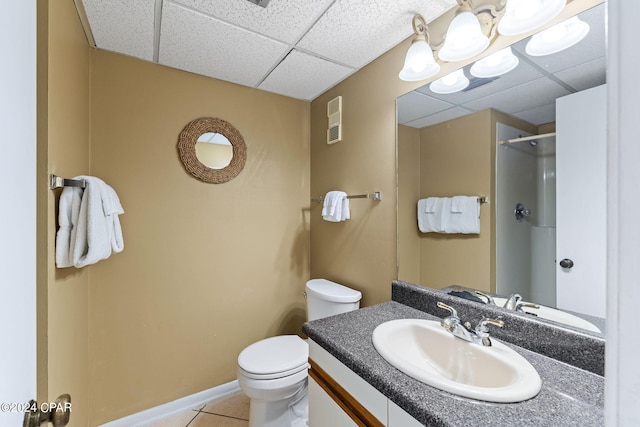 bathroom with a drop ceiling, large vanity, tile floors, and toilet