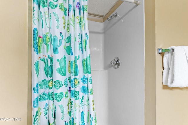 bathroom featuring curtained shower and a textured ceiling