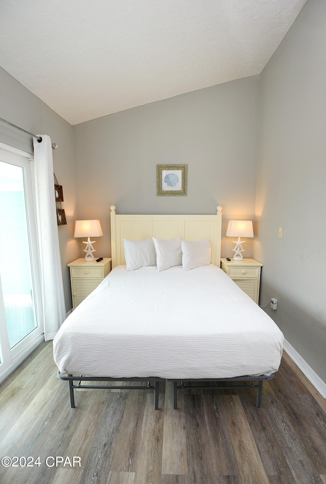 bedroom with vaulted ceiling and wood-type flooring