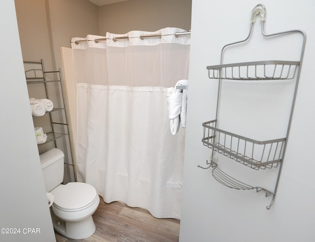 bathroom with toilet, curtained shower, and hardwood / wood-style floors